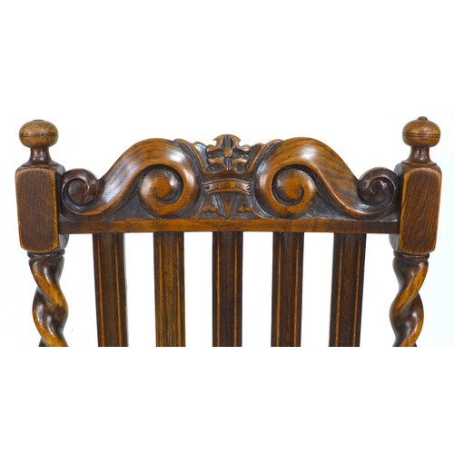 242 - A set of four Edwardian oak dining chairs, with carved crests to the rails, five splat back, and bar... 