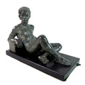 Karin Jonzen FRBS (British, 1914-1998): 'Reclining Youth', a bronze figural sculpture with a green p... 