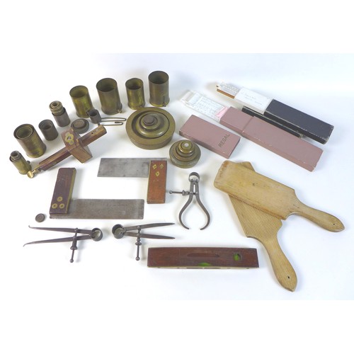48 - A collection of brass measuring tools including, brass weights, various measuring cups, two sliding ... 