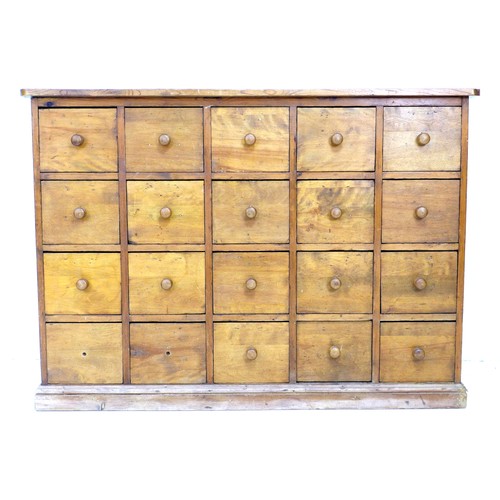 301 - An early to mid 20th century pine drawer unit, with an arrangement of twenty drawers, turned handles... 