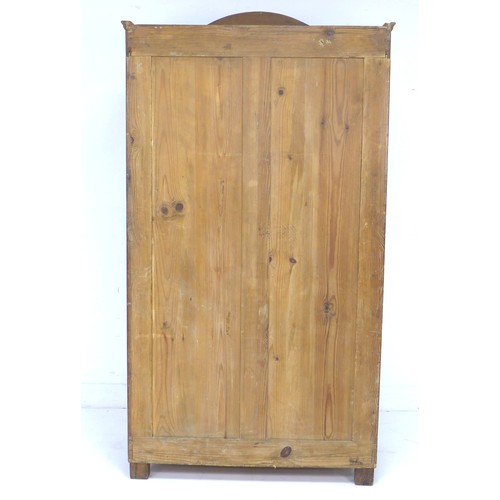 289 - A 19th century mahogany veneered wardrobe, single arched door enclosing a hanging space, raised on t... 