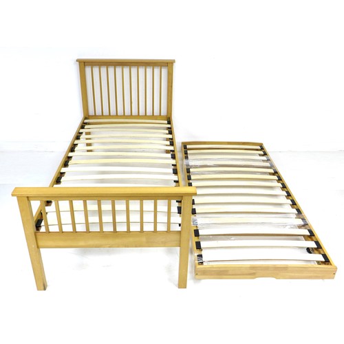 255 - A modern wooden single bed, with an additional pull out bed with sprung folding legs, slides and sto... 