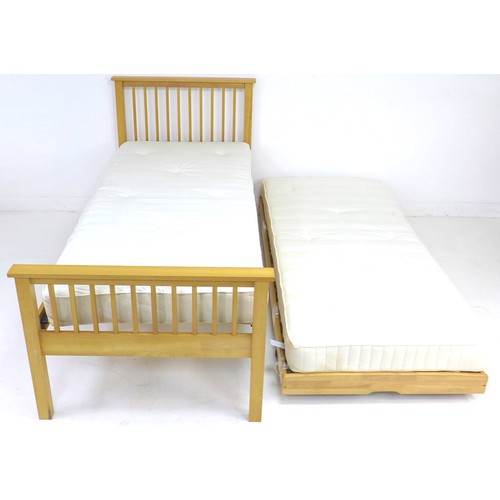 255 - A modern wooden single bed, with an additional pull out bed with sprung folding legs, slides and sto... 