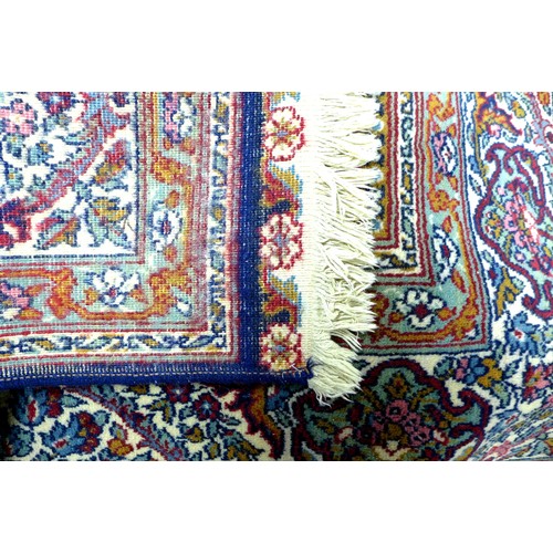 294 - A Persian rug with dark blue ground, profusely patterned red and multicoloured floral and scrolling ... 