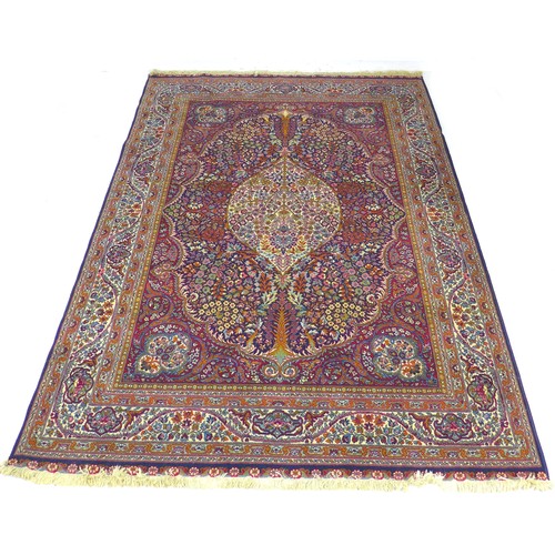 294 - A Persian rug with dark blue ground, profusely patterned red and multicoloured floral and scrolling ... 