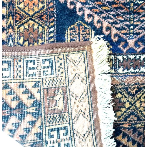 265 - A Persian wool prayer rug, the dark blue ground decorated with geometric designs in oranges and brow... 