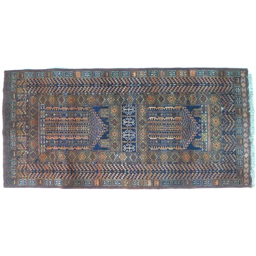 265 - A Persian wool prayer rug, the dark blue ground decorated with geometric designs in oranges and brow... 