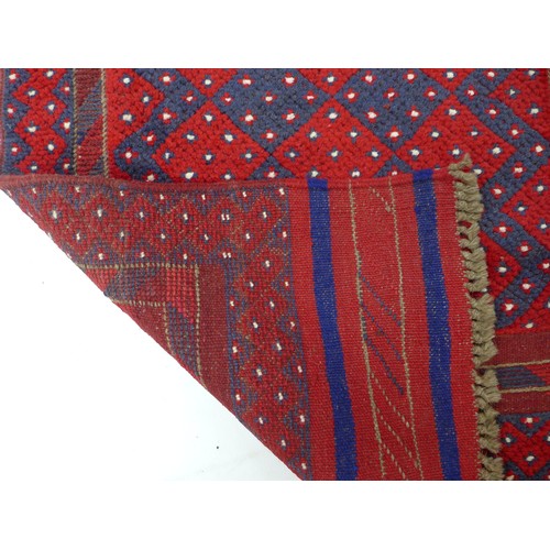 297 - A Meshwari runner with red and dark blue ground, diamond patterned and white flower speckled field, ... 