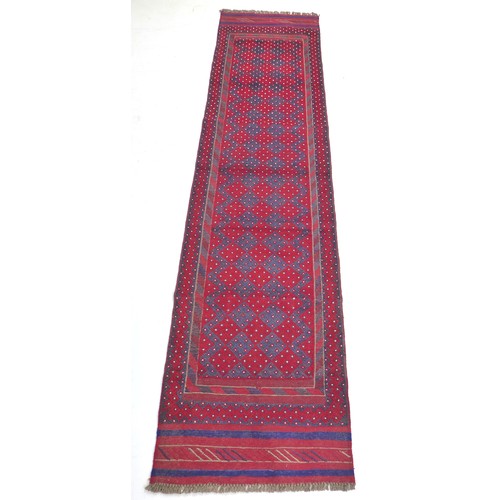 297 - A Meshwari runner with red and dark blue ground, diamond patterned and white flower speckled field, ... 