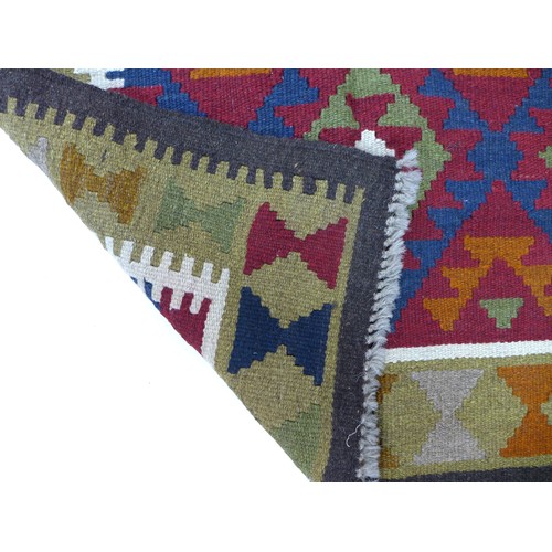 272 - A Maimana Kilim rug with dark blue ground, three white, red, and olive green lozenges, white and gre... 