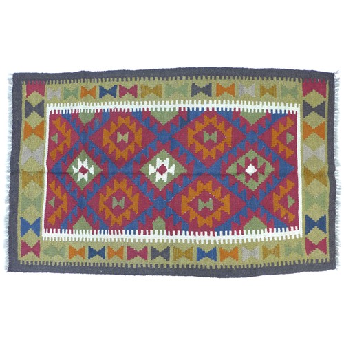 272 - A Maimana Kilim rug with dark blue ground, three white, red, and olive green lozenges, white and gre... 