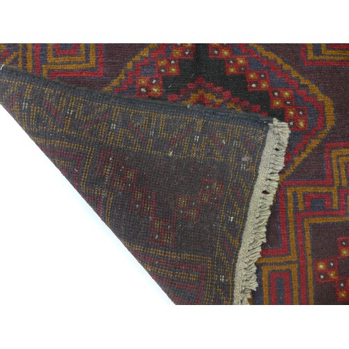 282 - A Baluchi rug with red ground, two medallions in shade varying shades of brown with thin red and bro... 