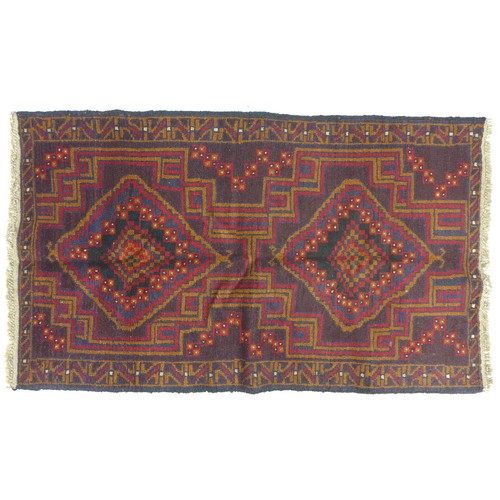 282 - A Baluchi rug with red ground, two medallions in shade varying shades of brown with thin red and bro... 