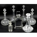 A group of seven glass decanters, comprising a simple, heavy rectangular whisky decanter, 12 by 7.5 ... 
