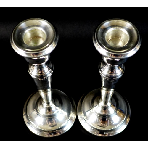 22 - A pair of silver candlesticks, each 21cm high with weighted bases, Francis Howard, Birmingham 1974, ... 