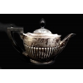 A Victorian silver teapot, of tapering cylindrical form with reeded lower body, ebonised handle and ... 