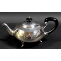 An Arts & Crafts silver teapot, of compressed ovoid form, with all over hammered finish, ebonised fi... 
