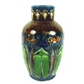 An Art Nouveau pottery vase, with stylised flowers incised into the body, over glazed in majolica ma... 