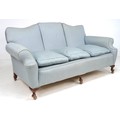 An Edwardian three seater settee, shaped back, loose seat cushions, upholstered in pale blue fabric,... 