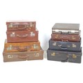 A group of eight vintage suitcases and valises, largest 64 by 40 by 16cm high and the smallest 42 by... 