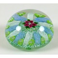 A Paul Ysart style paperweight, the mottled green ground decorated with a central pink flower with t... 