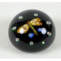 A Paul Ysart style paperweight, the black ground with dragon fly to the centre with orange wings and... 