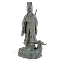 A cast metal sculpture, modelled as the Daoist figure Lu Dongbin standing on a sea monster, with swo... 
