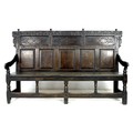 A 17th century provincial oak settle, the rectangular back with a decorative frieze and three panels... 