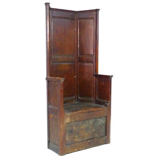 377 - An 18th century oak porter's chair, the high six panel back over a box base, the front panel hinged ...