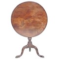 A George III mahogany tilt top occasional table, circular surface on a turned support and tripod bas... 