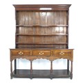 A 18th century oak dresser, with a closed back   three shelf top, the base with three frieze drawers... 