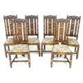 A set of six stained oak dining chairs, in Carolean style with heavily carved backs, the top rail ce... 