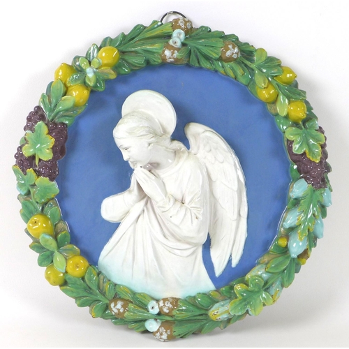 12 - A Continental 'Della Robbia' faience and terracotta relief plaque, depicting an angel in prayer, wit... 