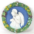 A Continental 'Della Robbia' faience and terracotta relief plaque, depicting an angel in prayer, wit... 
