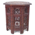 An Indian or Moorish octagonal small table intricately carved and pierced to the panels, with foliat... 