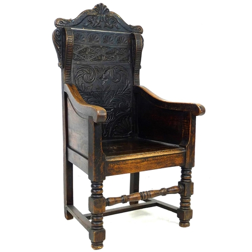 229 - An oak Wainscot type armchair, 19th century with some 17th century parts, the solid back carved with... 