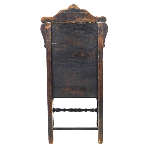 229 - An oak Wainscot type armchair, 19th century with some 17th century parts, the solid back carved with... 