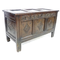 A 18th century oak chest, with three panelled front, lift lid, carved with diamond shapes below a pa... 
