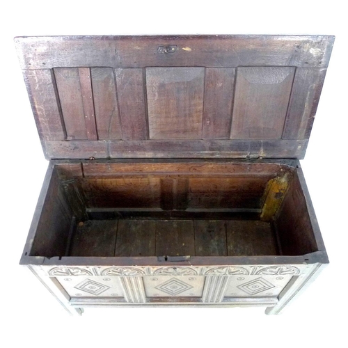 236 - A 18th century oak chest, with three panelled front, lift lid, carved with diamond shapes below a pa... 