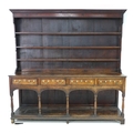 A large George III oak Welsh dresser, cornice over a closed three shelf waterfall plate rack, the ba... 