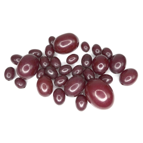 170 - A group of loose cherry amber bakelite beads, largest 22.9mm by 18.6mm, smallest 10mm by 7.6mm, 34.3... 