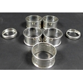 A collection of seven George V silver napkin rings, comprising a pair of napkin rings with reeded ba... 