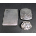 Two silver cigarette cases, one Edward VII, the body engraved with scrolling foliage, central circul... 