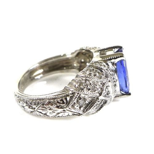 316 - A 14ct white gold and tanzanite dress ring, the single oval stone, 10 by 8mm, set to white gemset sh... 