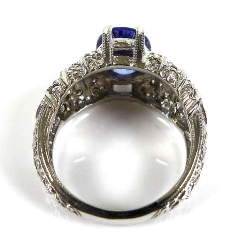 316 - A 14ct white gold and tanzanite dress ring, the single oval stone, 10 by 8mm, set to white gemset sh... 