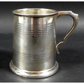 A George V silver 1/2 pint tankard, with stepped rim and base, scroll handle and two bands of reeded... 