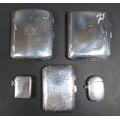A collection of three silver cigarette cases and two silver vesta cases, one a scrolling foliate eng... 