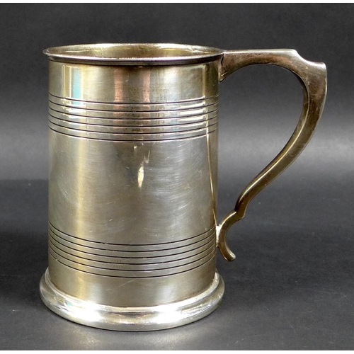 62 - A George V silver 1 pint tankard, with stepped rim and base, scroll handle and two bands of reeded d... 