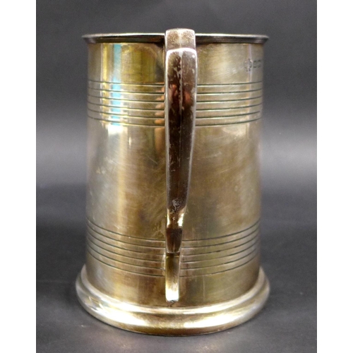 62 - A George V silver 1 pint tankard, with stepped rim and base, scroll handle and two bands of reeded d... 