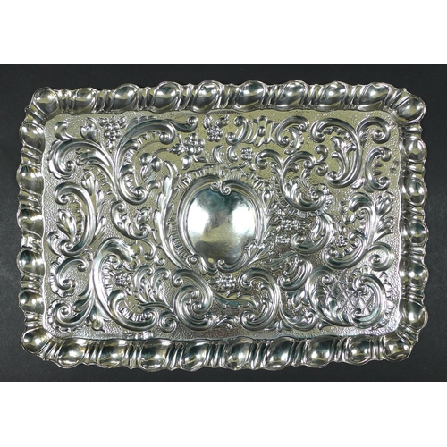 68 - An Edward VII silver dressing table tray, of rectangular form with embossed Rococo style decoration,... 